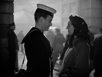 Movie still from “In Which We Serve” (1942), directed by Noël Coward – A man and a woman are talking to each other; Medium shot, Over the shoulder angle