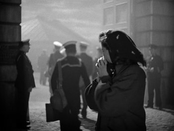 Movie still from “In Which We Serve” (1942), directed by Noël Coward – An old photo of a woman on her cell phone; Medium shot, High angle