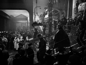 Movie still from “In Which We Serve” (1942), directed by Noël Coward – A group of people standing on top of a set of stairs; Extreme Wide shot, High angle