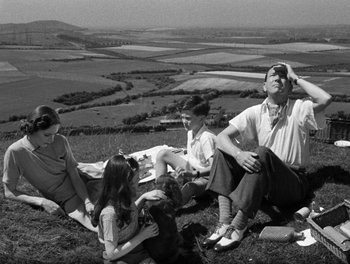 Movie still from “In Which We Serve” (1942), directed by Noël Coward – A black and white photo of a group of people sitting on top of a hill; Medium shot, High angle