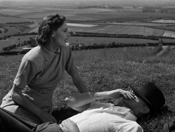 Movie still from “In Which We Serve” (1942), directed by Noël Coward – An old black and white photo of a man and a woman; Medium shot, High angle