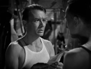 Movie still from “In Which We Serve” (1942), directed by Noël Coward – A black and white photo of a man talking to another man; Close Up shot, Over the shoulder angle