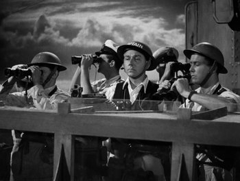Movie still from “In Which We Serve” (1942), directed by Noël Coward – A black and white photo of a group of men looking through binoculars; Medium shot, Low angle