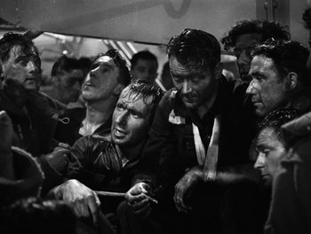Movie still from “In Which We Serve” (1942), directed by Noël Coward – Black and white photograph of a group of men on a train; Medium shot, High angle