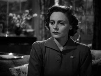 Movie still from “In Which We Serve” (1942), directed by Noël Coward – A woman sitting on a couch in front of a window; Close Up shot, Low angle