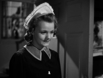 Movie still from “In Which We Serve” (1942), directed by Noël Coward – A young woman wearing a nurse's hat and a dress; Close Up shot, Low angle