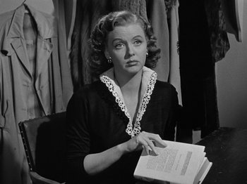 Movie still from “In a Lonely Place” (1950), directed by Nicholas Ray – An old photo of a woman holding a stack of papers; Close Up shot, Over the shoulder angle