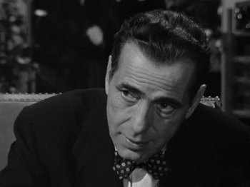 Movie still from “In a Lonely Place” (1950), directed by Nicholas Ray – Black and white photograph of a man wearing a bow tie; Close Up shot, Over the shoulder angle