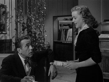 Movie still from “In a Lonely Place” (1950), directed by Nicholas Ray – A man and a woman are talking to each other; Medium shot, Over the shoulder angle