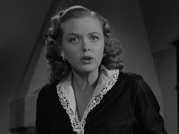Movie still from “In a Lonely Place” (1950), directed by Nicholas Ray – A black and white photo of a woman in a black dress; Close Up shot, Low angle