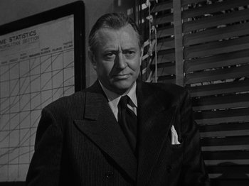 Movie still from “In a Lonely Place” (1950), directed by Nicholas Ray – An older man wearing a suit and tie; Close Up shot, Low angle