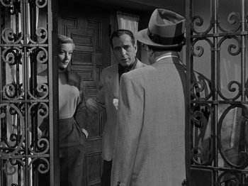 Movie still from “In a Lonely Place” (1950), directed by Nicholas Ray – A black and white photo of a man and a woman in front of a mirror; Medium shot, Over the shoulder angle