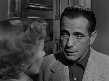 Movie still from “In a Lonely Place” (1950), directed by Nicholas Ray – An old photo of a man and a young woman looking at each other; Close Up shot, Over the shoulder angle