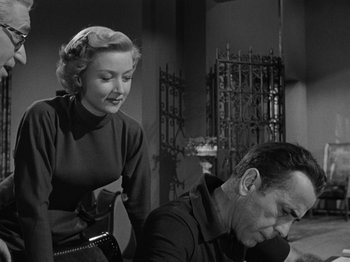 Movie still from “In a Lonely Place” (1950), directed by Nicholas Ray – An older woman standing next to an older man in a room; Medium shot, Low angle
