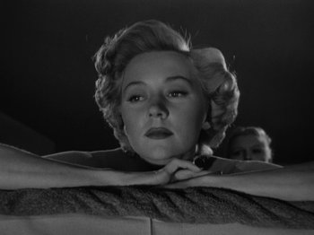 Movie still from “In a Lonely Place” (1950), directed by Nicholas Ray – A black - and - white photo of a woman with a bow in her hair; Close Up shot, Low angle