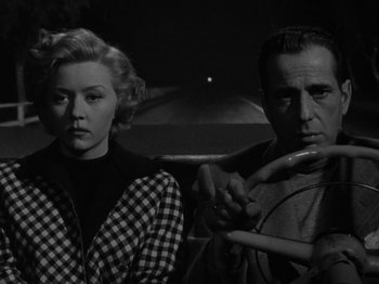 Movie still from “In a Lonely Place” (1950), directed by Nicholas Ray – A man and a woman standing next to each other; Medium shot, Low angle