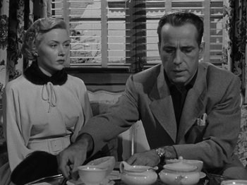 Movie still from “In a Lonely Place” (1950), directed by Nicholas Ray – A man and a woman sitting at a dinner table; Medium shot, Over the shoulder angle