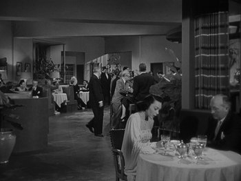 Movie still from “In a Lonely Place” (1950), directed by Nicholas Ray – A black and white photo of people in a restaurant; Wide shot, High angle