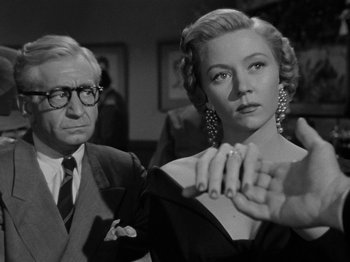 Movie still from “In a Lonely Place” (1950), directed by Nicholas Ray – A man and a woman are standing next to each other; Medium shot, Low angle