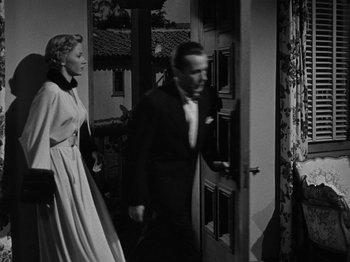 Movie still from “In a Lonely Place” (1950), directed by Nicholas Ray – A black and white photo of a man and a woman; Wide shot, Over the shoulder angle