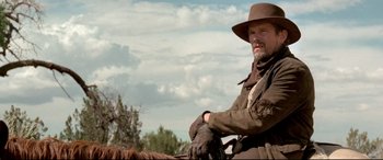 Movie still from “In a Valley of Violence” (2016), directed by Ti West – A man sitting on top of a brown horse; Medium shot, Low angle