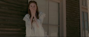 Movie still from “In a Valley of Violence” (2016), directed by Ti West – A woman in a white dress covers her mouth with her hands; Medium shot, Overhead angle