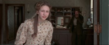 Movie still from “In a Valley of Violence” (2016), directed by Ti West – A young woman in a floral dress in front of an old man; Close Up shot, Over the shoulder angle