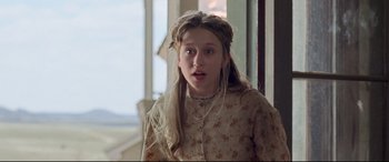 Movie still from “In a Valley of Violence” (2016), directed by Ti West – A young girl with long blonde hair wearing a floral dress; Close Up shot, Low angle