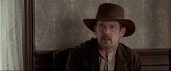 Movie still from “In a Valley of Violence” (2016), directed by Ti West – A person wearing a hat; Close Up shot, Over the shoulder angle