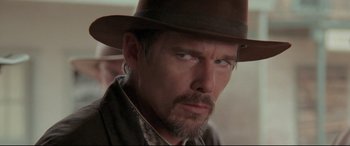 Movie still from “In a Valley of Violence” (2016), directed by Ti West – A person wearing a hat; Close Up shot, Over the shoulder angle