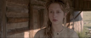 Movie still from “In a Valley of Violence” (2016), directed by Ti West – A young girl with long hair and a brown shirt; Close Up shot, Low angle