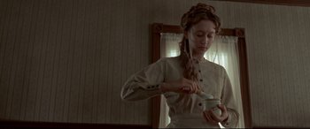 Movie still from “In a Valley of Violence” (2016), directed by Ti West – A woman in a white dress is holding a bowl; Medium shot, Low angle