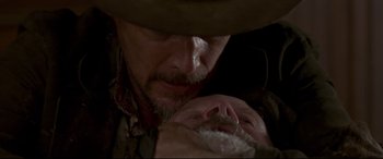 Movie still from “In a Valley of Violence” (2016), directed by Ti West – A person with a beard and a hat; Close Up shot, Over the shoulder angle