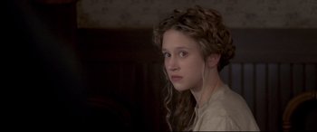 Movie still from “In a Valley of Violence” (2016), directed by Ti West – A young woman with long hair and a white shirt; Close Up shot, High angle