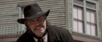 Movie still from “In a Valley of Violence” (2016), directed by Ti West – A man in a black hat and a black suit; Close Up shot, Low angle