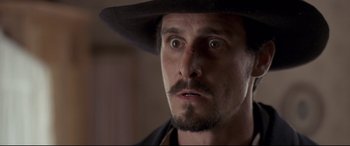 Movie still from “In a Valley of Violence” (2016), directed by Ti West – A person wearing a hat; Close Up shot, Low angle
