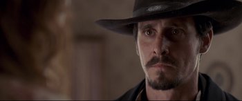 Movie still from “In a Valley of Violence” (2016), directed by Ti West – A person wearing a hat; Close Up shot, Over the shoulder angle