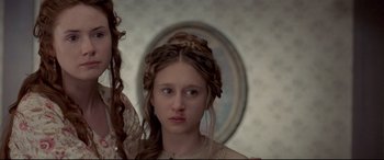 Movie still from “In a Valley of Violence” (2016), directed by Ti West – A young woman with long hair in front of a mirror; Close Up shot, Low angle