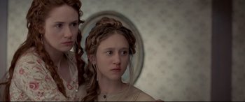 Movie still from “In a Valley of Violence” (2016), directed by Ti West – Two young girls standing next to each other in front of a mirror; Close Up shot, Low angle