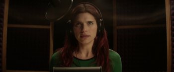 A woman wearing headphones in a recording studio