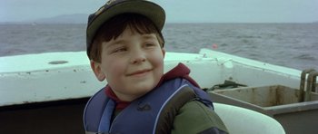 Movie still from “In the Bedroom” (2001), directed by Todd Field – A young boy wearing a life jacket on a boat in the ocean; Close Up shot, Low angle
