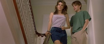 Movie still from “In the Bedroom” (2001), directed by Todd Field – A young woman walking up a staircase while holding the handrail of a railing; Medium shot, Low angle