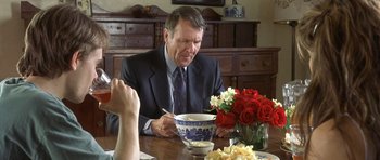 Movie still from “In the Bedroom” (2001), directed by Todd Field – An older man sitting at a table with a bowl of food; Medium shot, Over the shoulder angle