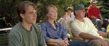 Movie still from “In the Bedroom” (2001), directed by Todd Field – A woman sitting next to two men in a park; Medium shot, Over the shoulder angle