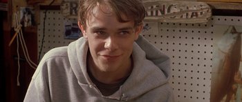 Movie still from “In the Bedroom” (2001), directed by Todd Field – A young man wearing a gray hoodie smiling for the camera; Close Up shot, Low angle