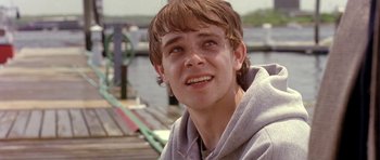 Movie still from “In the Bedroom” (2001), directed by Todd Field – A young man smiling for the camera; Close Up shot, Over the shoulder angle