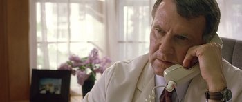 Movie still from “In the Bedroom” (2001), directed by Todd Field – An older man talking on a phone while sitting in a chair; Close Up shot, Low angle
