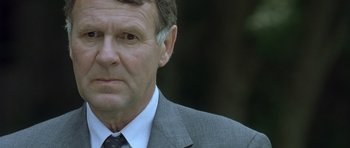 Movie still from “In the Bedroom” (2001), directed by Todd Field – An older man in a suit and tie looking at the camera; Close Up shot, Over the shoulder angle