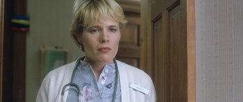 Movie still from “In the Bedroom” (2001), directed by Todd Field – A woman wearing a stethoscope is standing in front of a door; Close Up shot, Low angle