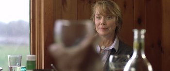 Movie still from “In the Bedroom” (2001), directed by Todd Field – A woman sitting at a table with a glass of wine; Close Up shot, Over the shoulder angle